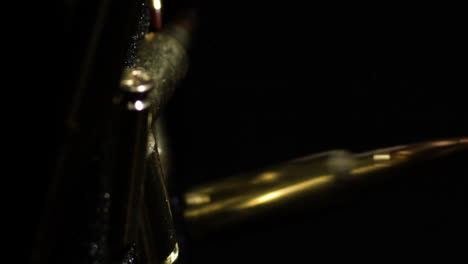 vertical close up shot of bullets 6mm arc falling on gunpowder pile, slowmo