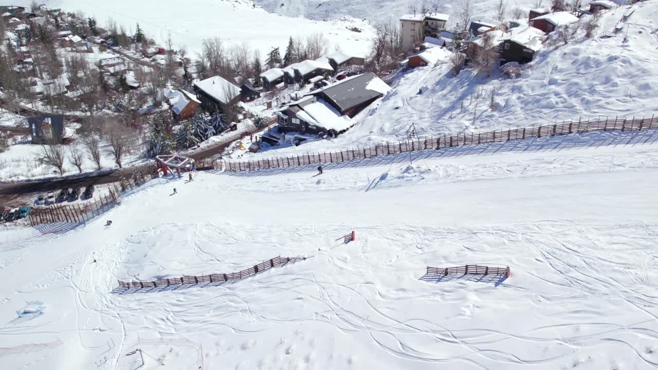 воздушная орбита человека, поднимающегося по лыжному склону фареллонес через т-образный подъемник, параллаксный эффект заснеженной деревни фареллонес