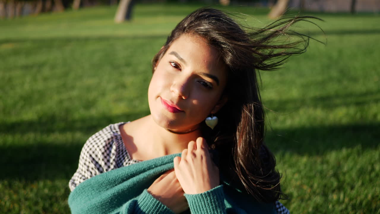 Close up of a young hispanic woman trying to get warm and cozy with her sweater in cold windy weather