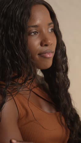 studio beauty shot of smiling young woman with long hair against neutral background