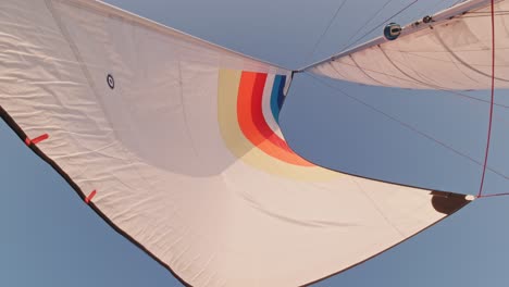 top view of vessel with open white sails waving in the wind with clear skies