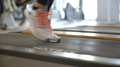 feet of a woman on a running machine at a gym, close up