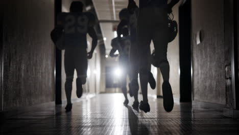 football players running down hallway