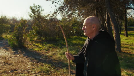 elderly sorcerer walking in nature in search of something