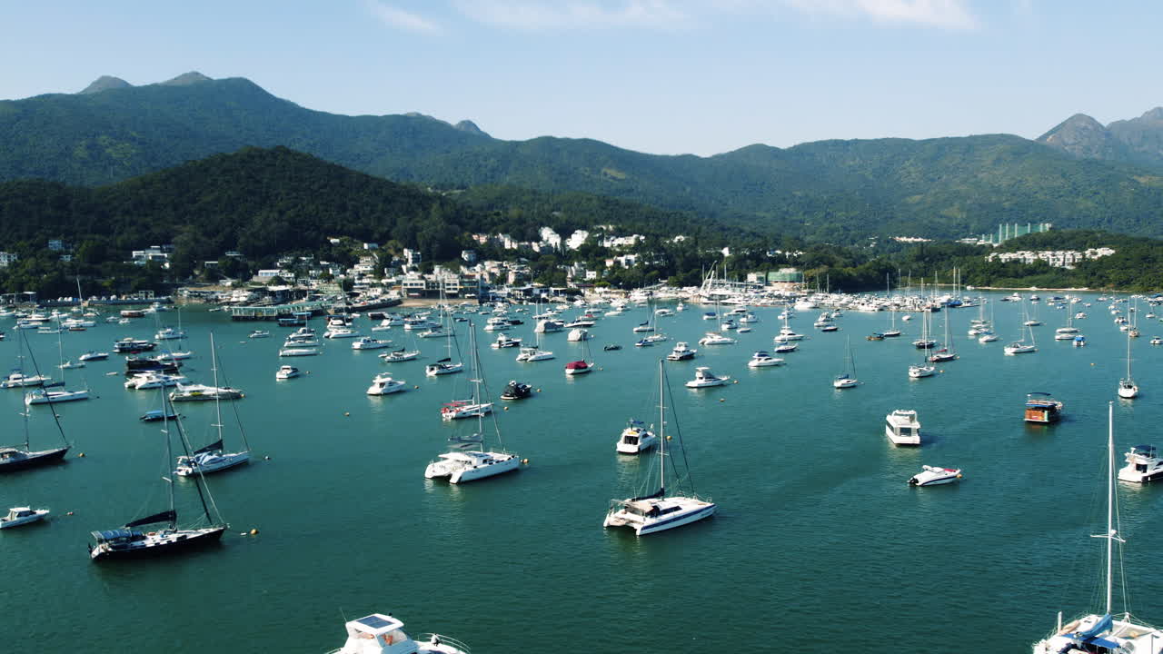 Veduta aerea dall'alto di numerose barche e yacht ormeggiati in marina.