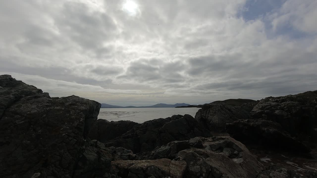 lapso de tiempo de la cubierta de nubes bajas pasando sobre el océano rocoso costa británica