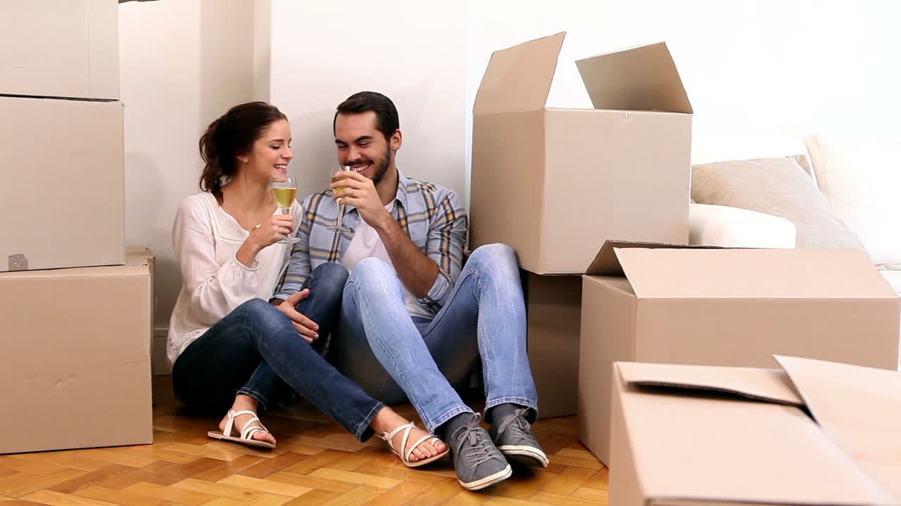 una pareja atractiva celebrando su mudanza.