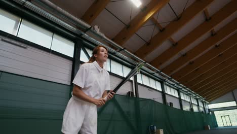 woman playing indoor tennis