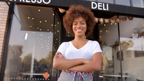 dona negra proprietária entra em plano focal do lado de fora da cafeteria
