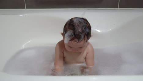 baby girl clapping hands white taking foamy bath