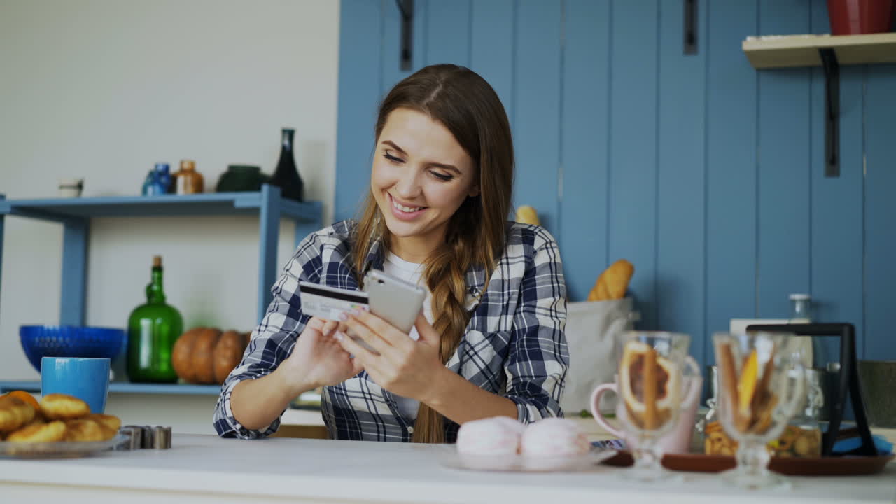 Woman making a mobile payment in the kitchen