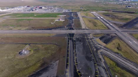 Empty-airfield-runway-of-Keflavik-International-Airport,-new-taxiway-Mike,-aerial