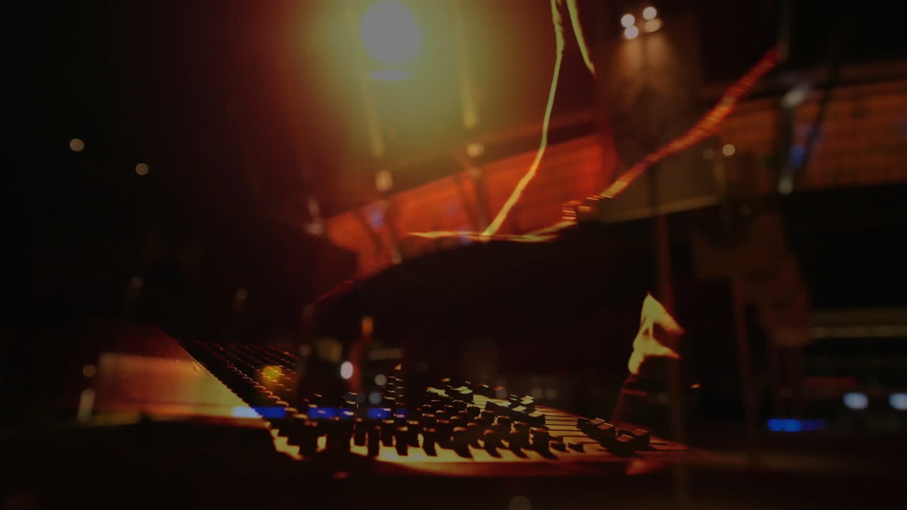 Music producer adjusting console knobs under spotlight, LED lights with animated waveform overlay