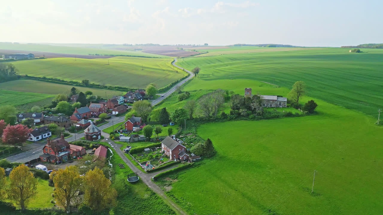 Aerial drone scene depicts Burwell village, once medieval market town—surrounding fields, ancient red brick homes, and the unused Saint Michael parish church on Lincolnshire's Wold Hills