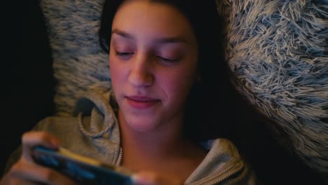 teenage girl relaxing on a cozy couch, intently using her smartphone. warm natural lighting enhances the tranquil and casual atmosphere.
