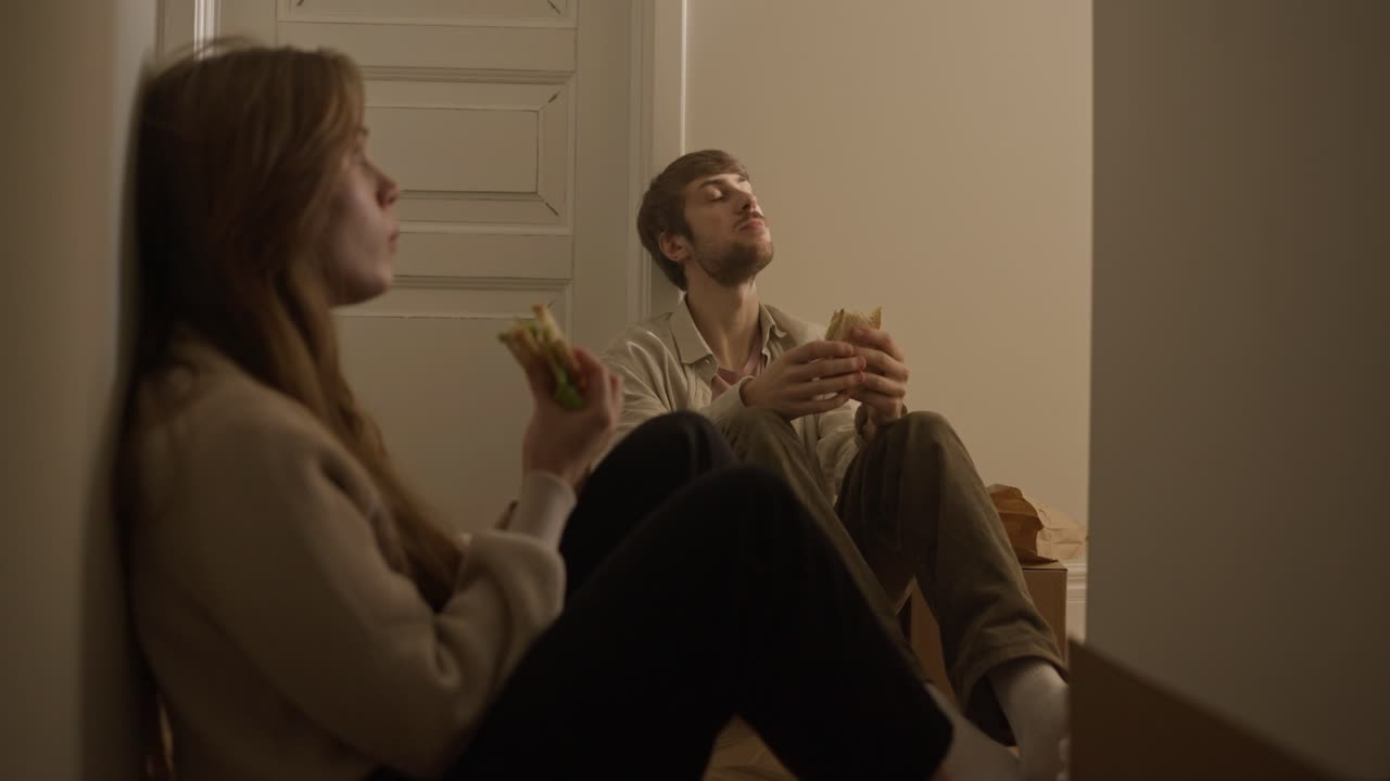 пара ест сэндвичи во время передвижения