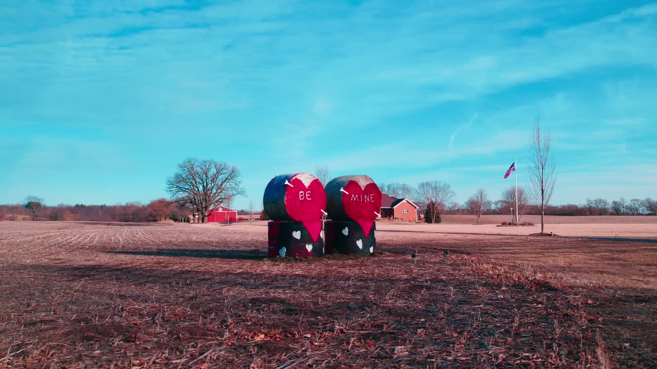 Valentine’s setup featuring heart-painted hay bales reading “Be Mine,” adorning a rustic field near Woodstock, Illinois.