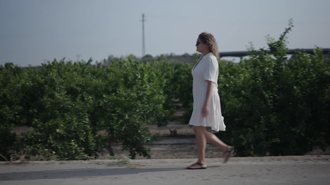 Woman Walking in an Orange Orchard
