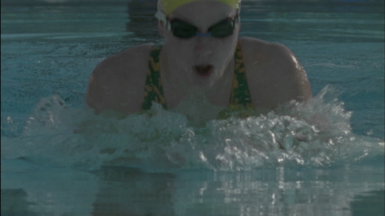 пловец соревнуется в стиле брасс в плавательном бассейне