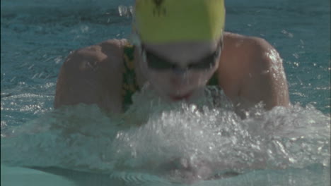 swimmer competes in breaststroke style in a swimming pool