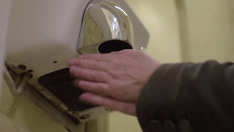 Using-an-electric-hot-air-hand-dryer-in-a-public-washroom