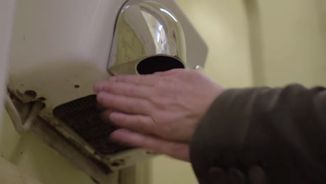 utilizar un secador de manos eléctrico de aire caliente en un baño público.