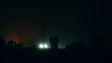 People Walking on a Foggy Night Road