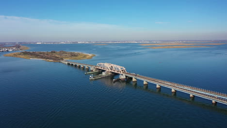 an aerial shot over an elevated train track with a swing bridge