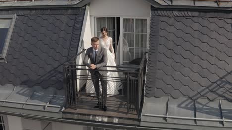 caucasian newlyweds bride embracing groom on balcony in hotel room, aerial view