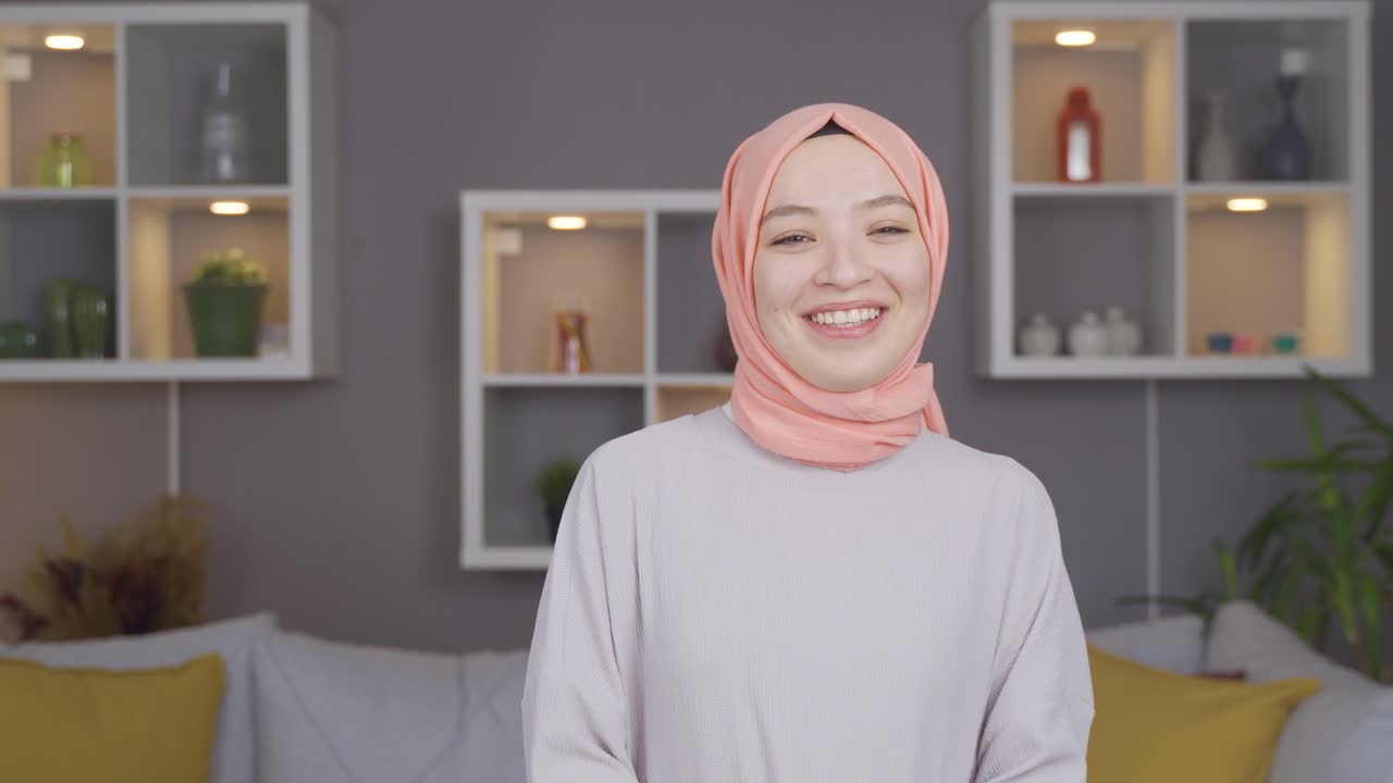 무슬림 여성이 카메라를 쳐다보고 미소 짓고 있습니다.