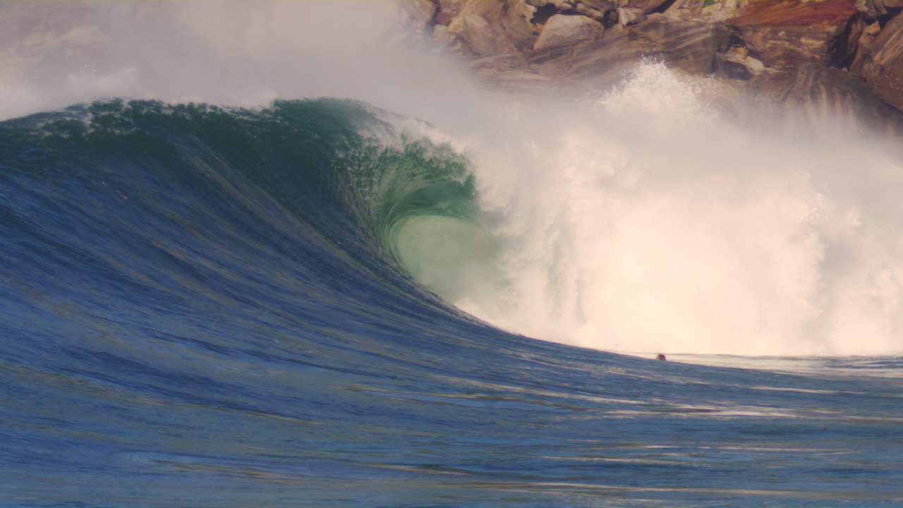 Stormy ocean waves crashing onto the shore in Sydney, Australia, with mist swirling.