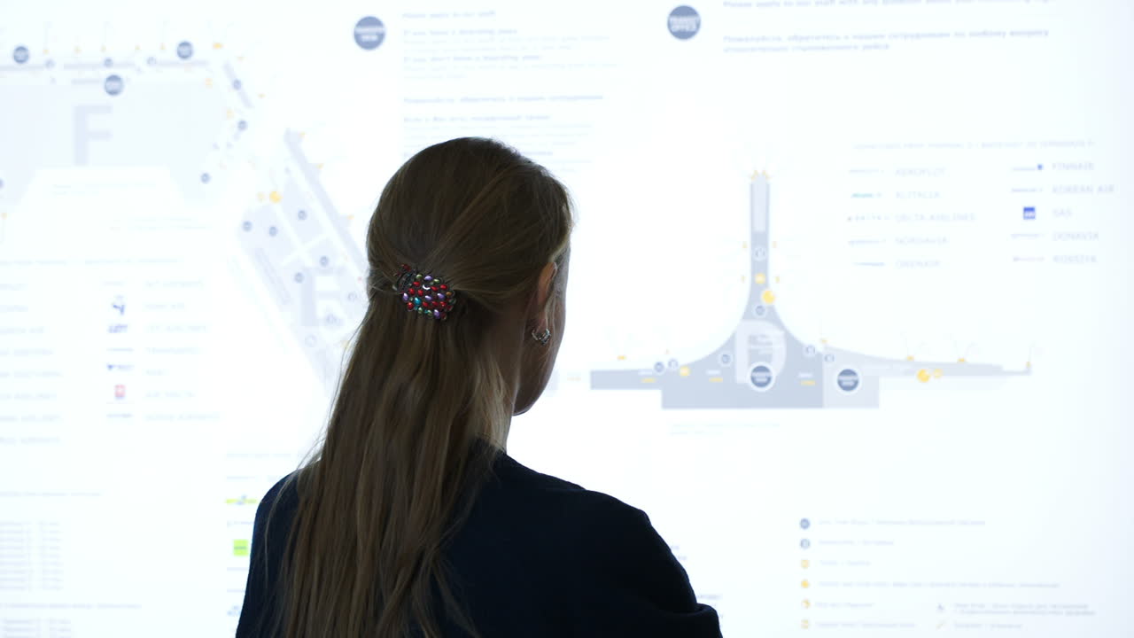 mujer explorando el mapa esquemático en el aeropuerto o el cementerio comercial