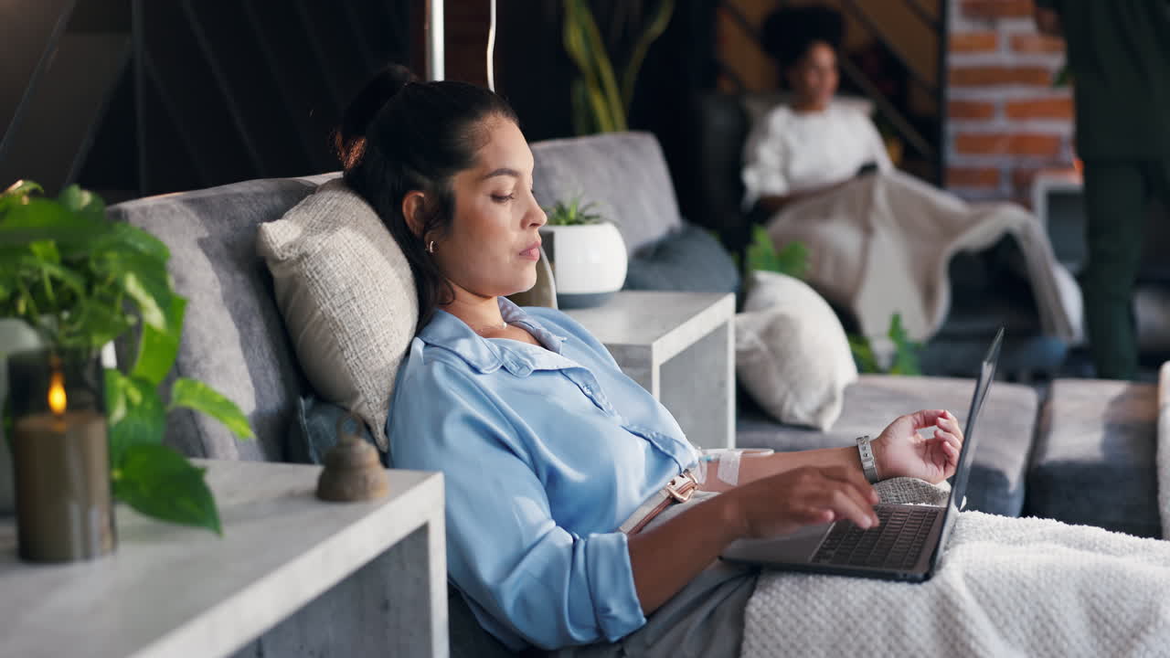 Woman Receiving IV Infusion While Working on Laptop