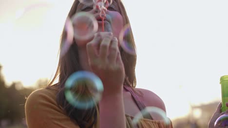 woman blowing soap bubbles at the summer party