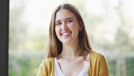 Portrait-of-happy-caucasian-woman-in-living-room-smiling-to-camera