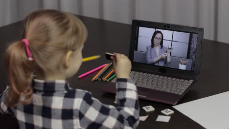 girl distance education lesson with woman teacher, using digital laptop at home