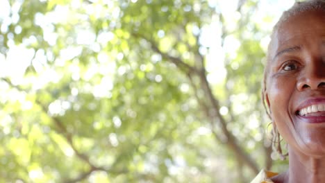 half portrait of happy senior african american woman on sunny terrace with copy space, slow motion