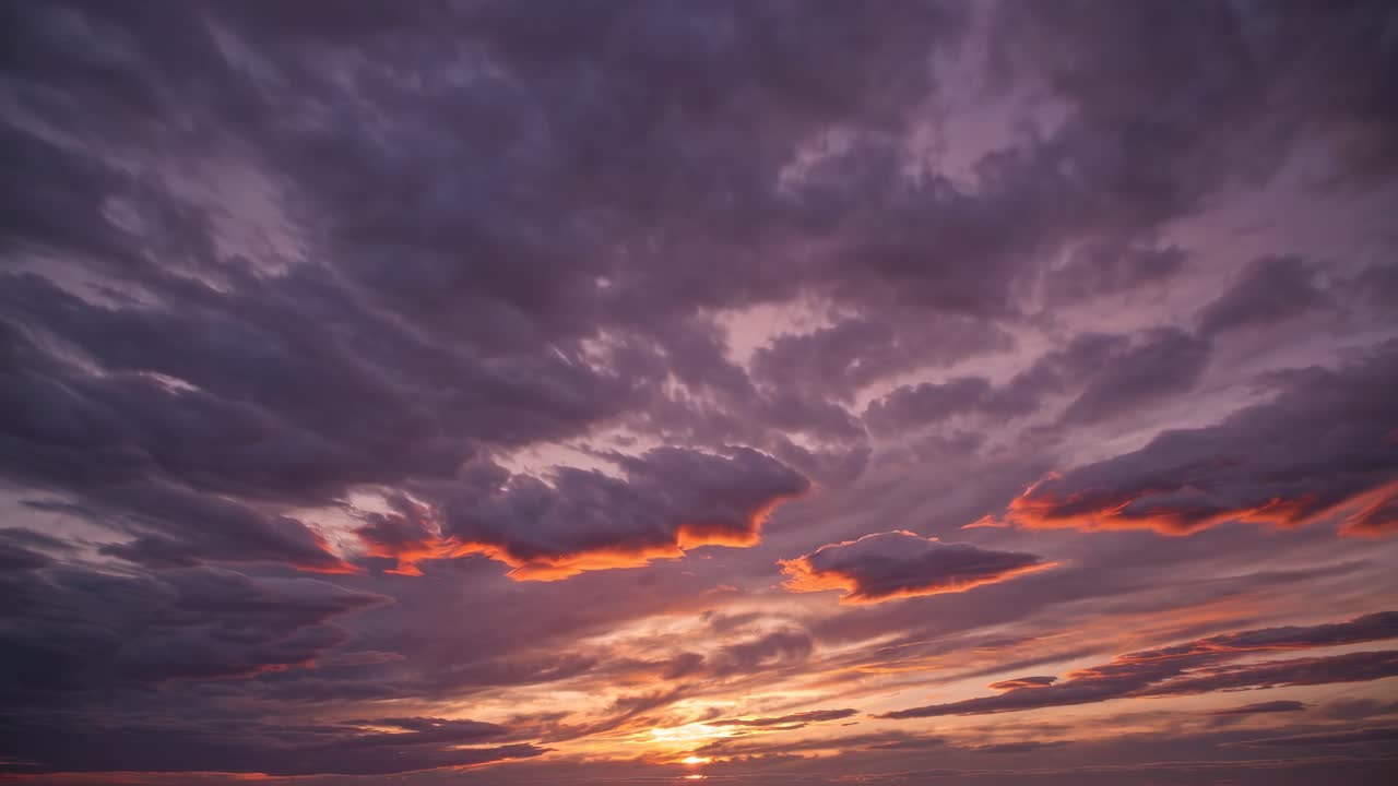 A wide-angle video captures a dramatic sunset sky with vibrant clouds, showcasing a serene
