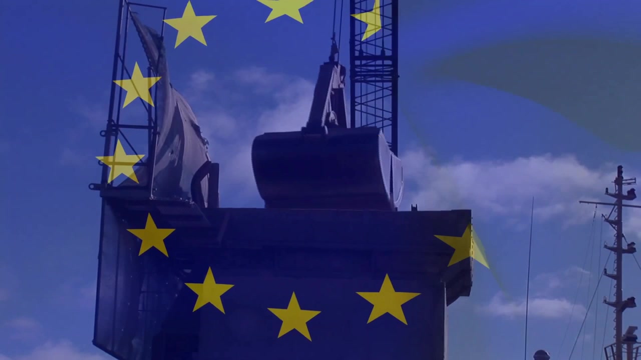 Sovrapposizione di stelle dell'UE che appare mentre una benna a conchiglia si abbassa, afferra e solleva un cilindro per il trasferimento.