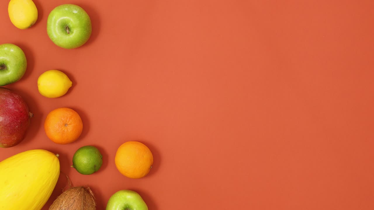 frutas tropicales de verano movimiento creativo en el lado izquierdo del fondo naranja. detener el movimiento