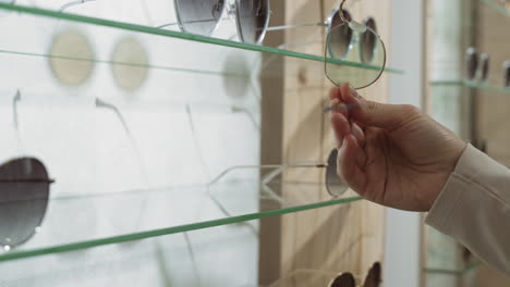 woman choosing sunglasses in a store