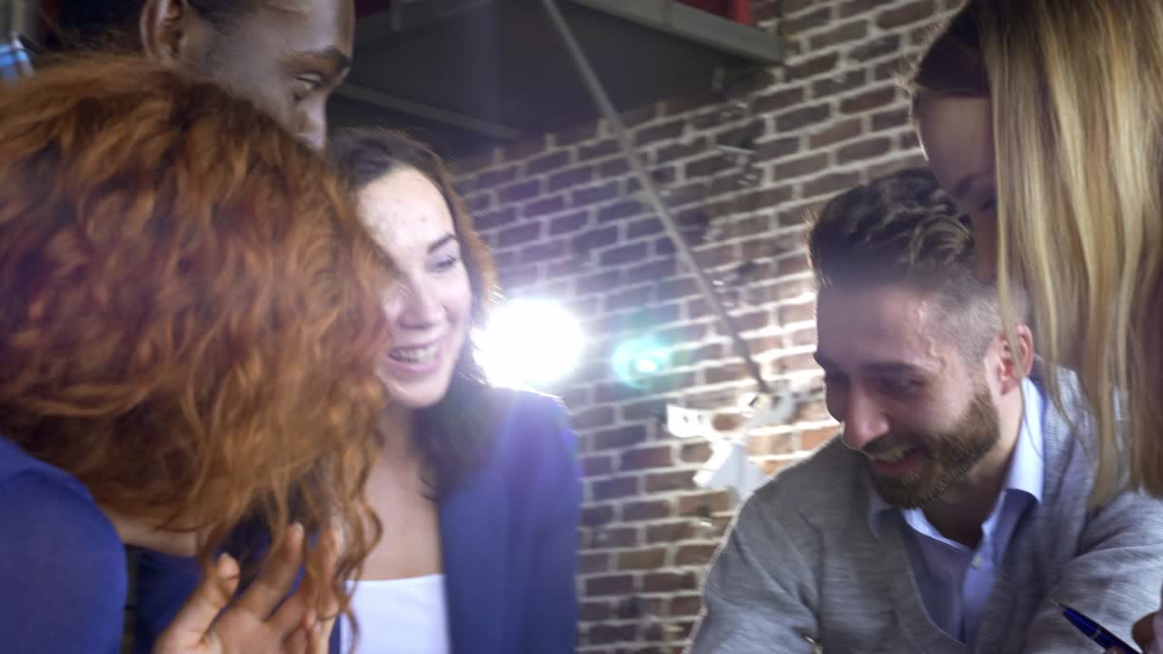 concepto de negocios, startups y personas - equipo creativo feliz con computadoras y carpetas discutiendo proyectos en un espacio compartido en el loft.