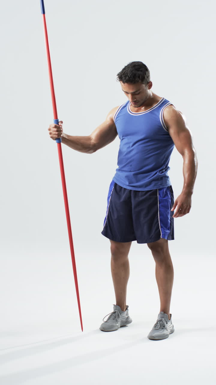 Vertical video: Holding javelin, athlete in sportswear preparing for track and field event