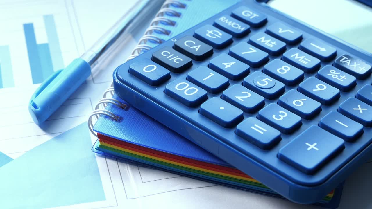 calculadora, cuaderno y bolígrafo en los documentos