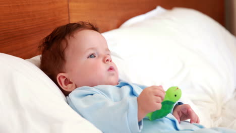 Niño-En-Babygro-Acostado-En-La-Cama