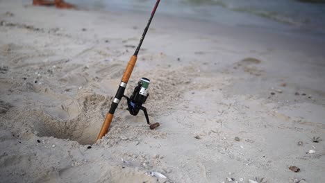 fishing spinning rod in the sand at hua hin beach, prachuap khiri khan, thailand