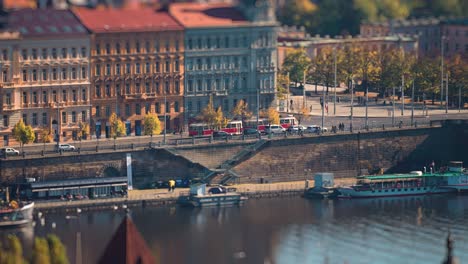 trams and cars rush along the vltava river embankment