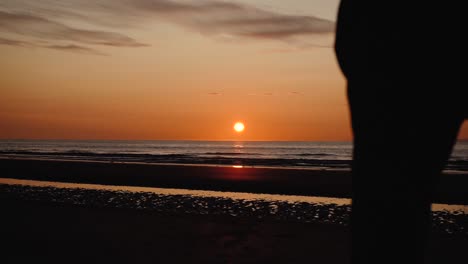 Man-running-with-guitar-in-back-sand-beach-at-sunset-30