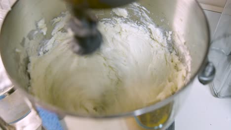 a static shot of butter cream frosting being whipped up