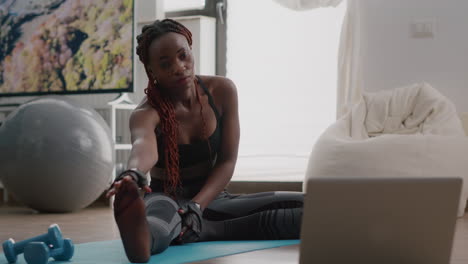 Woman-with-black-skin-doing-workout-in-living-room-stretching-exercise